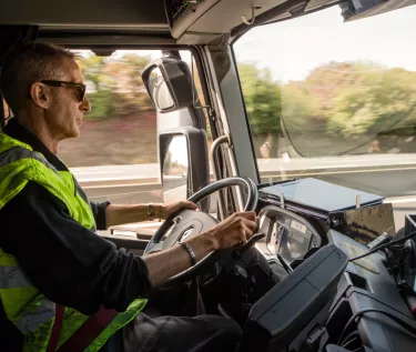 Tanker transport driver driving wearing a yellow jacket for safety