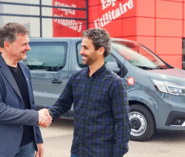 Trafic e-tech park in front of a dealer shop with two men shaking hands
